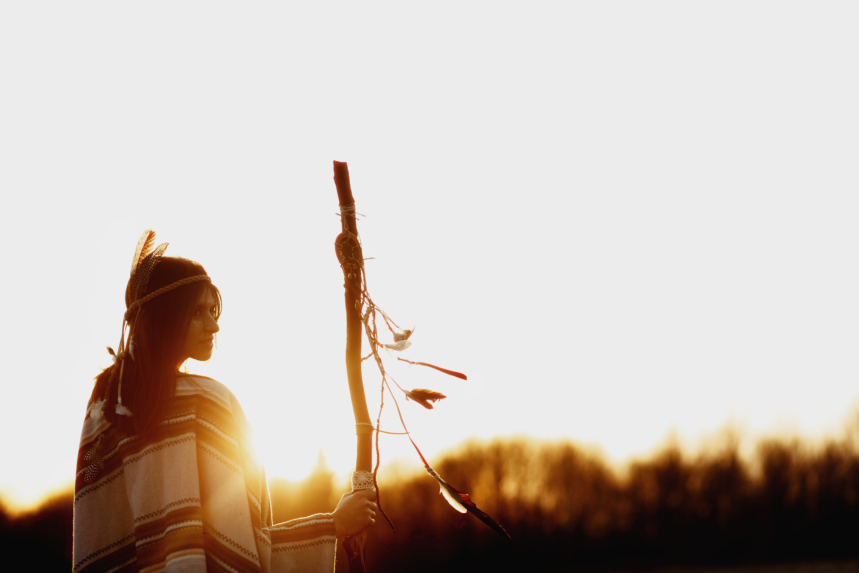 native american woman  shaman with pikestaff on background of sunset beutiful in mountains