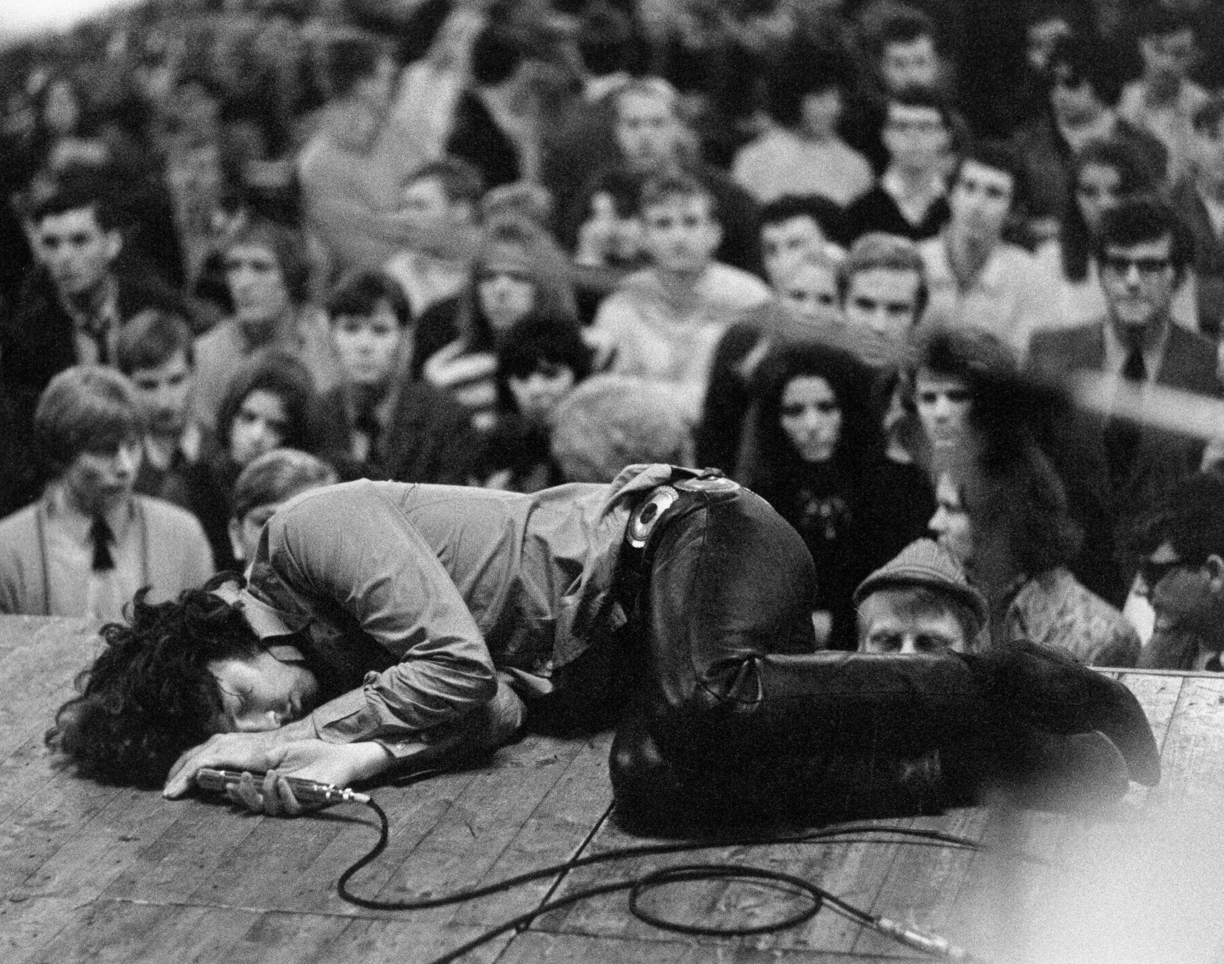 Jim Morrison laying on stage during a performance of The Doors ...