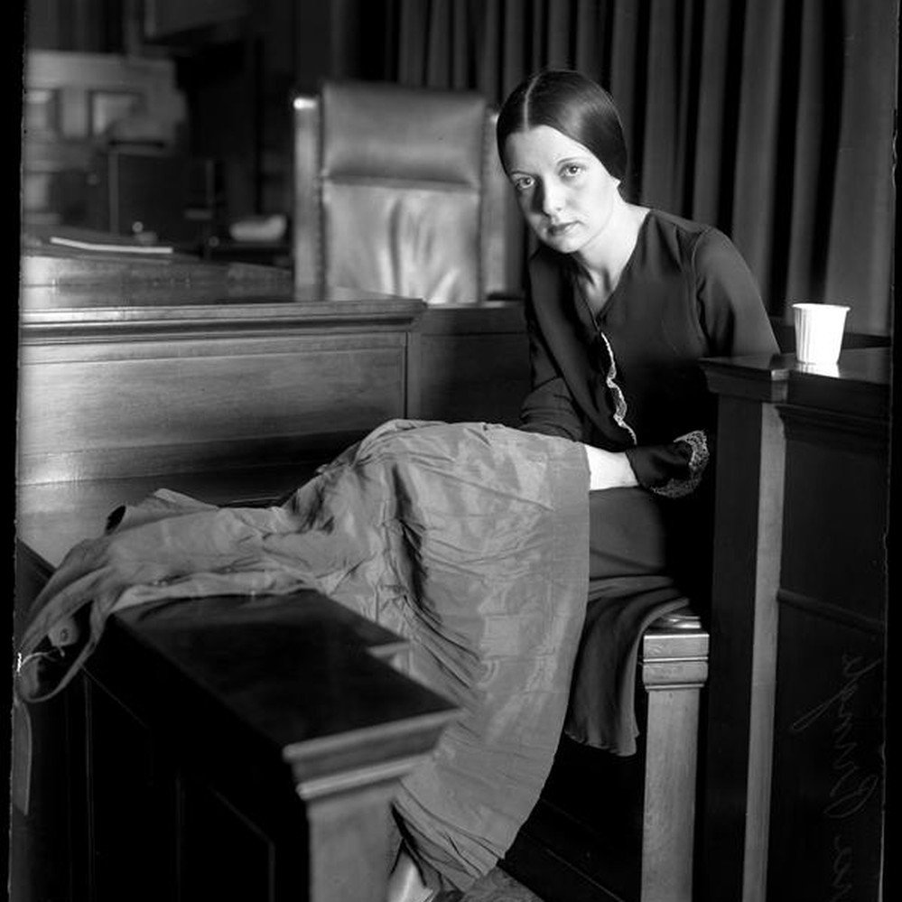 Eunice Pringle on the witness stand examining a dress during Alexander Pantages rape trial — Calisphere