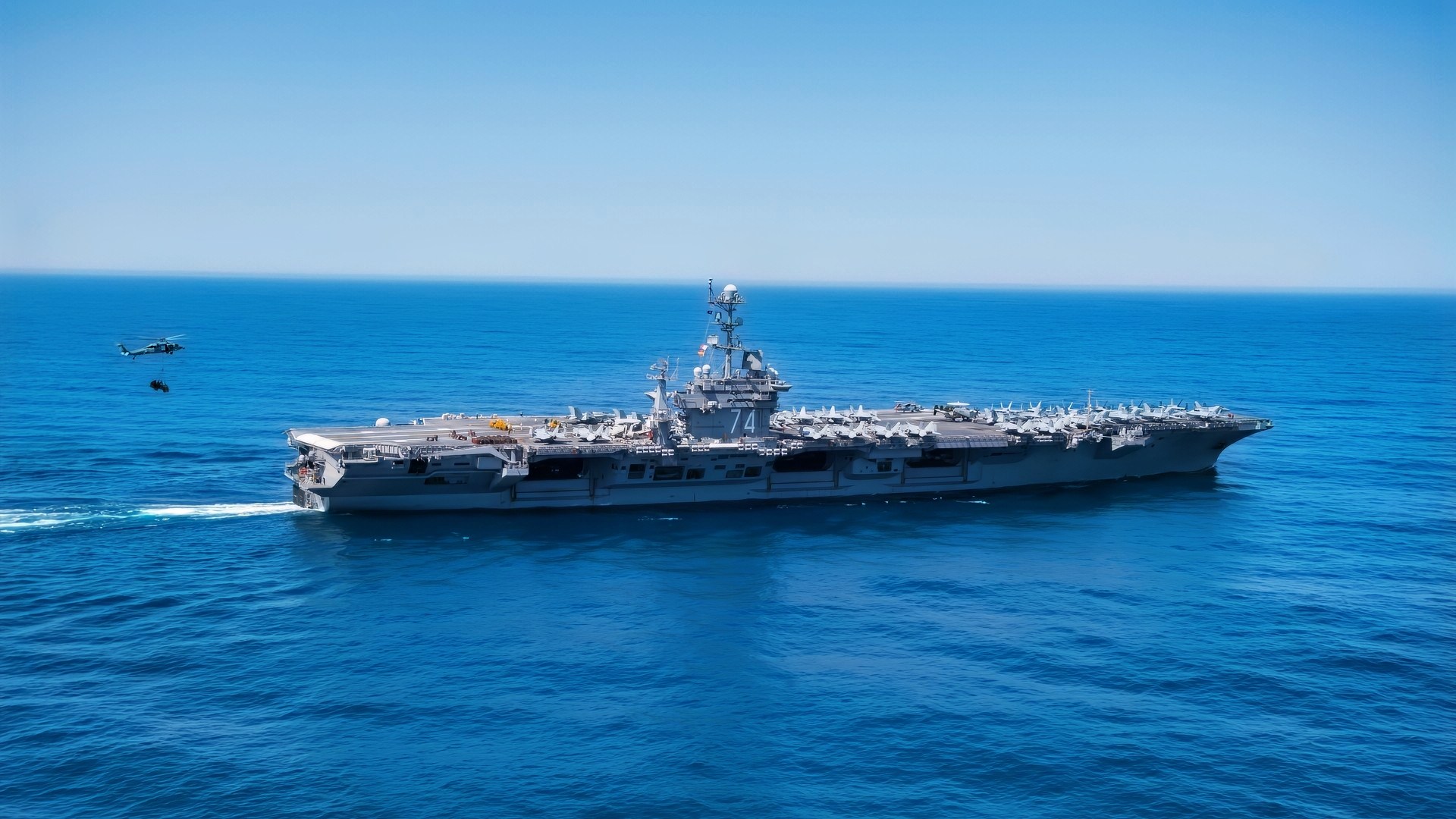 (April 14, 2018) An MH-60S Sea Hawk helicopter assigned to the "Chargers" of Helicopter Sea Combat Squadron (HSC) 14, prepares to onload cargo during a replenishment-at-sea between the aircraft carrier USS John C. Stennis (CVN 74) and the fleet replenishment oiler USNS Henry J. Kaiser (T-AO 187). John C. Stennis is underway with Carrier Air Wing (CVW) 9 conducting routine, tailored ships training availability and final evaluation problem. (U.S. Navy photo by Mass Communication Specialist 3rd Class William Ford/Released)