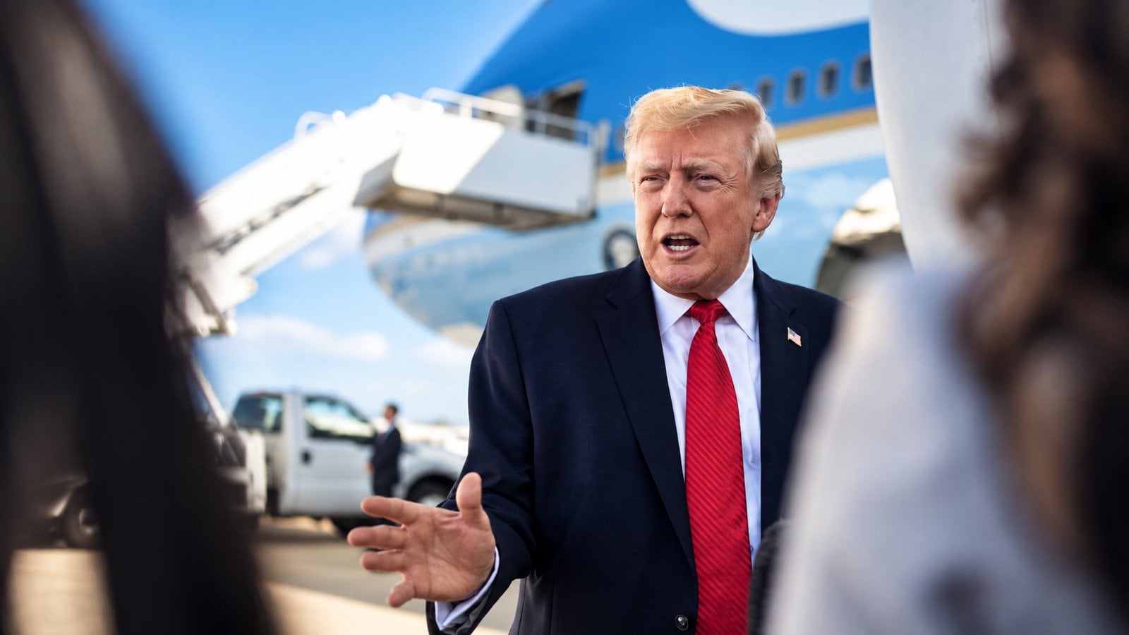 President Donald Trump speaks with reporters beside Air Force One